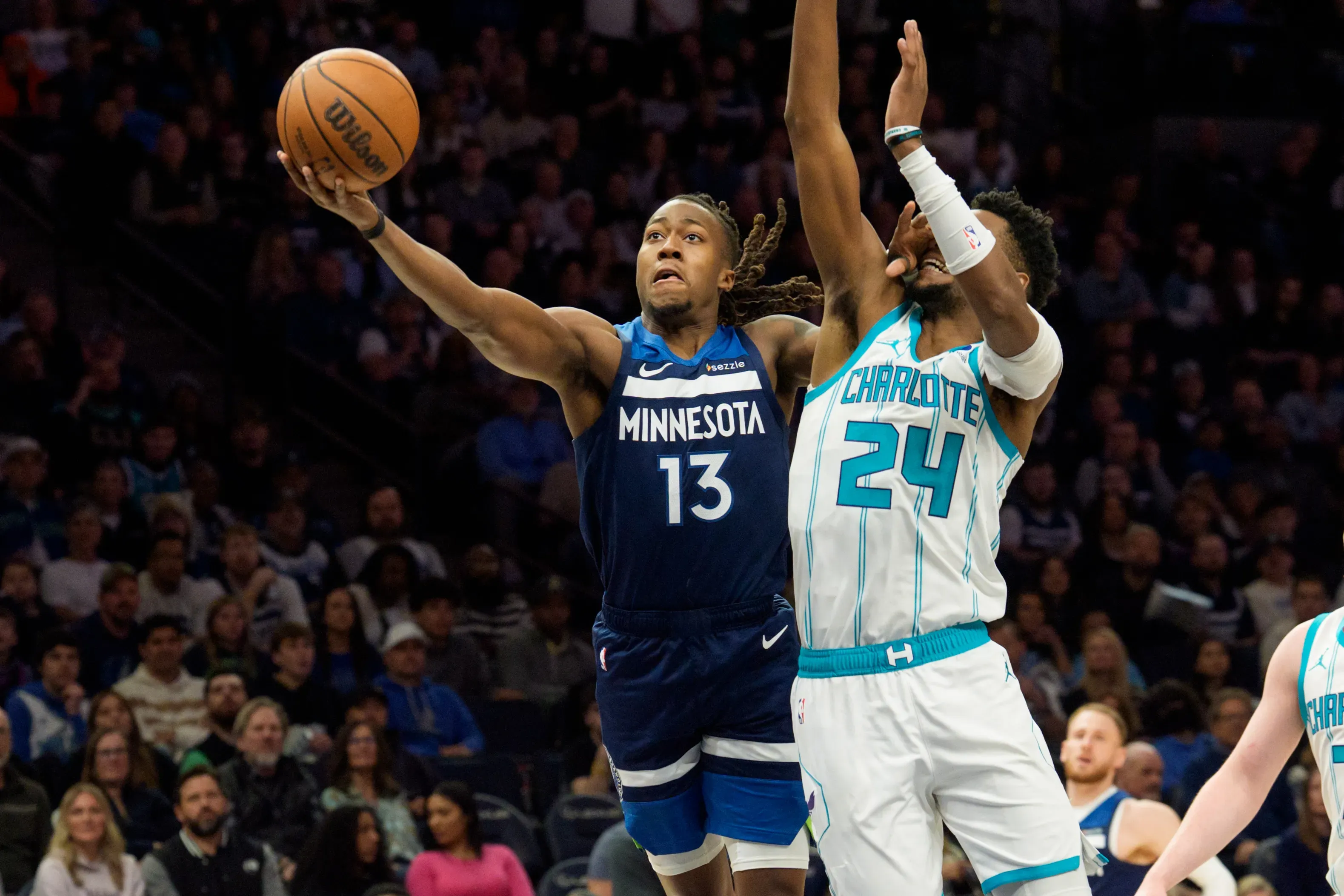 Minnesota Timberwolves guard Ayo Dosunmu (13) shoots past the defense of Charlotte Hornets forward Brandon Miller (24) in the second quarter at Target Center. Mandatory Credit: Matt Blewett-Imagn Images