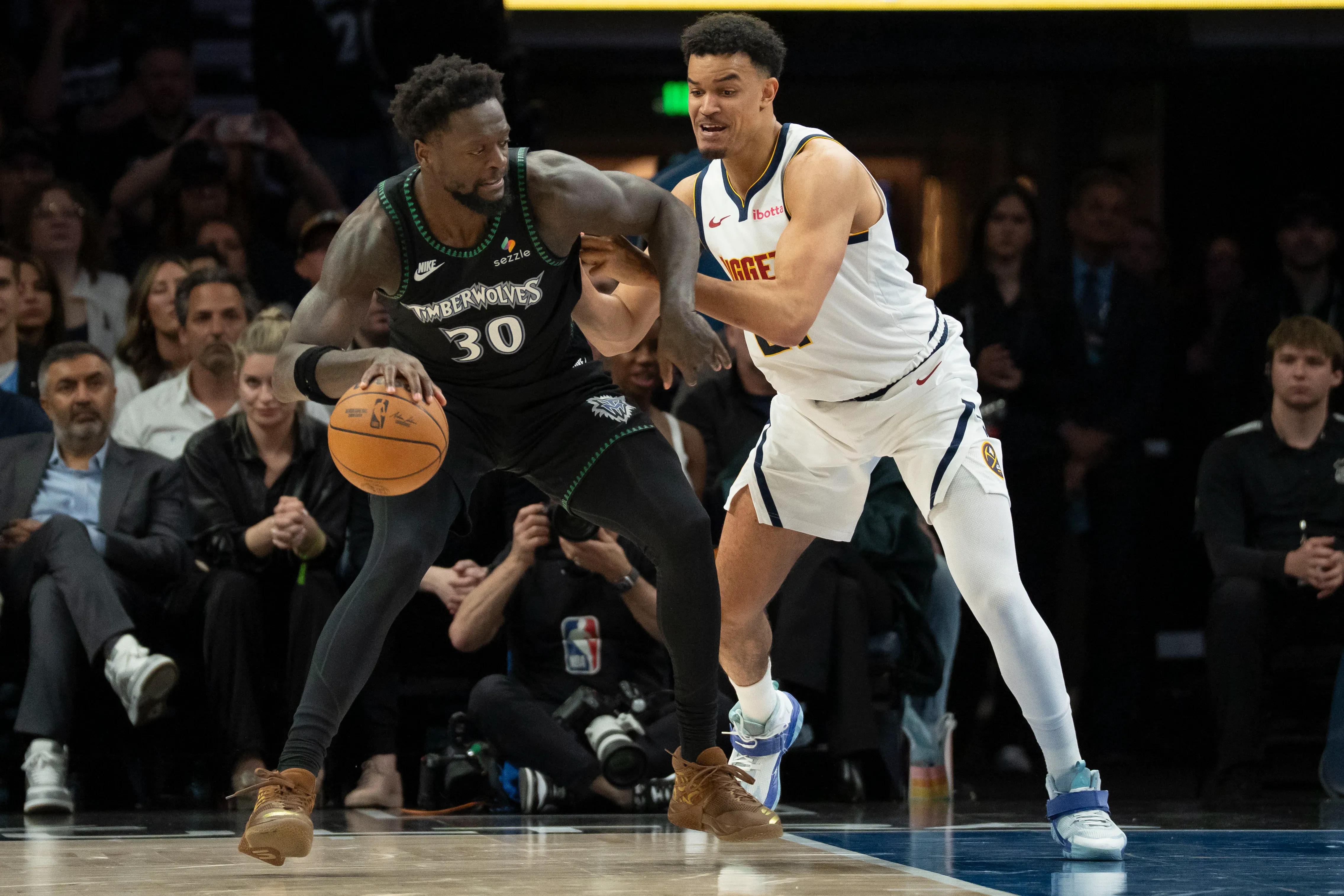 Minnesota Timberwolves forward Julius Randle (30) dribbles the ball as Denver Nuggets forward Spencer Jones (21) plays defense in the second half during game six of the first round of the 2026 NBA Playoffs at Target Center. Mandatory Credit: Jesse Johnson