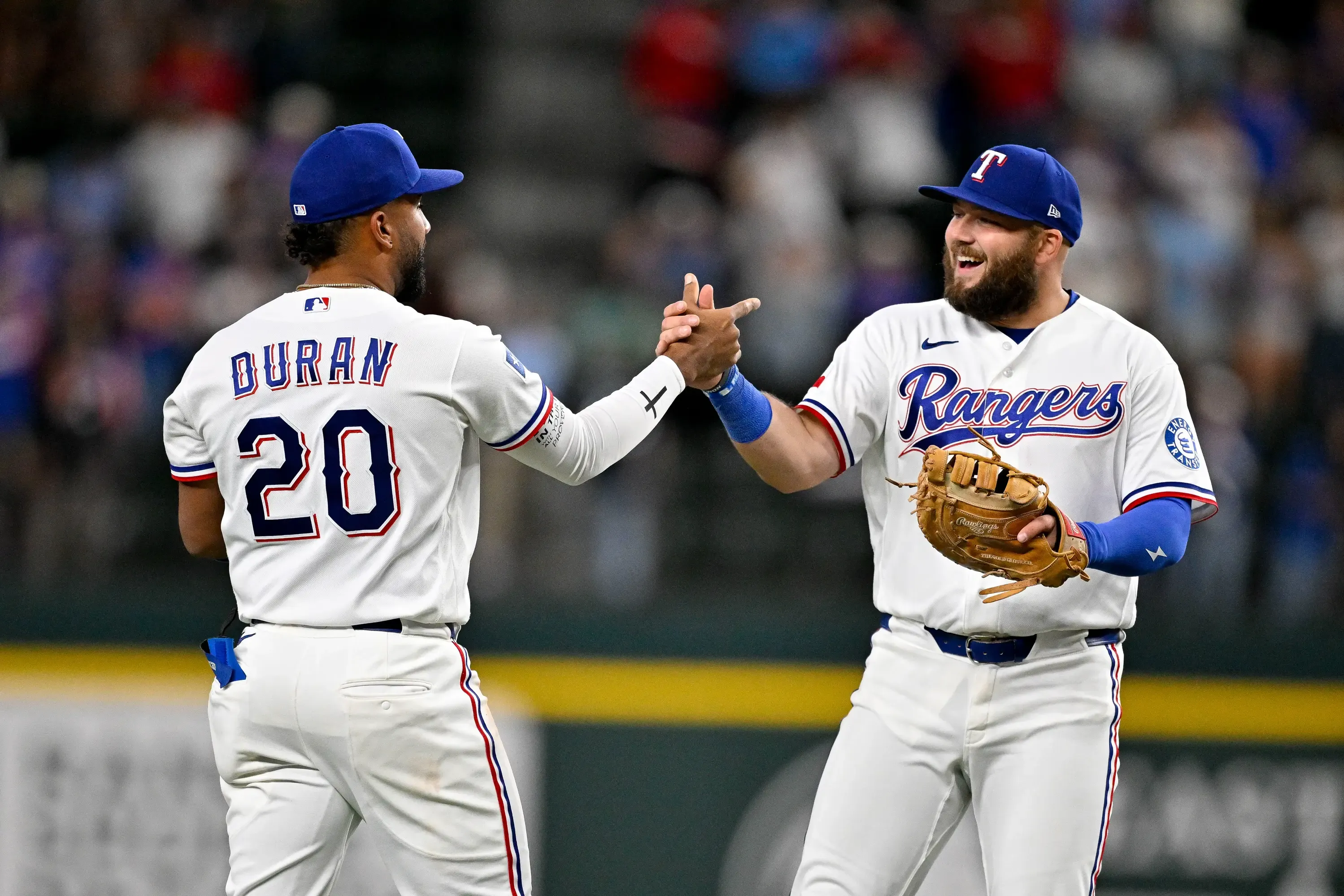 Texas Rangers first baseman Jake Burger (21) and third baseman Ezequiel Duran (20) celebrate the Rangers win over the Seattle Mariners at Globe Life Field. Mandatory Credit: Jerome Miron-Imagn Images
