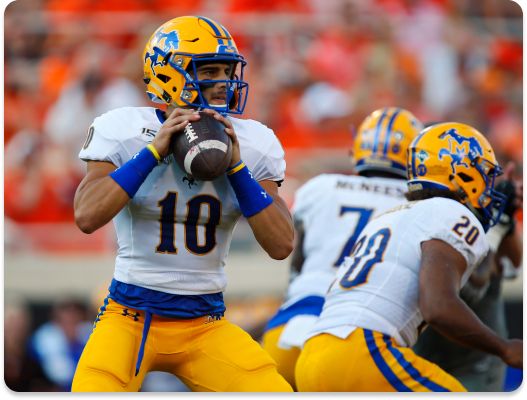 Quarterback Matt Keller #10 of the McNeese State Cowboys looks for a receiver against the Oklahoma State Cowboys